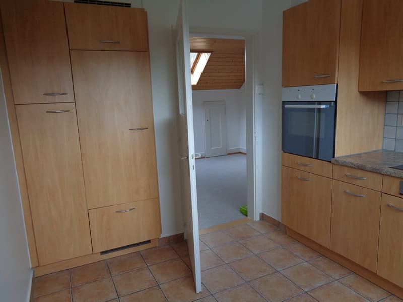 kitchen, wooden cabinets, tiled floor, open door to another room, built-in oven