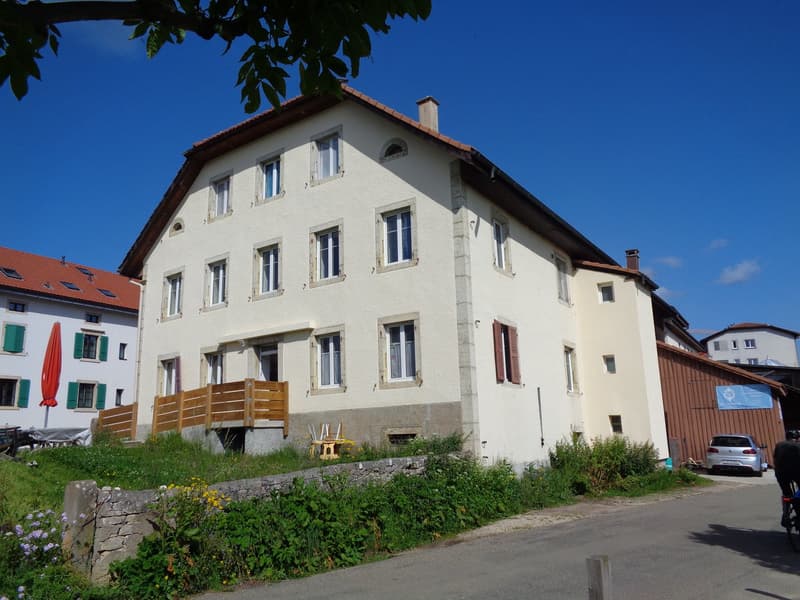 2 story house, white exterior, brown roof, several windows, small porch, garden in front