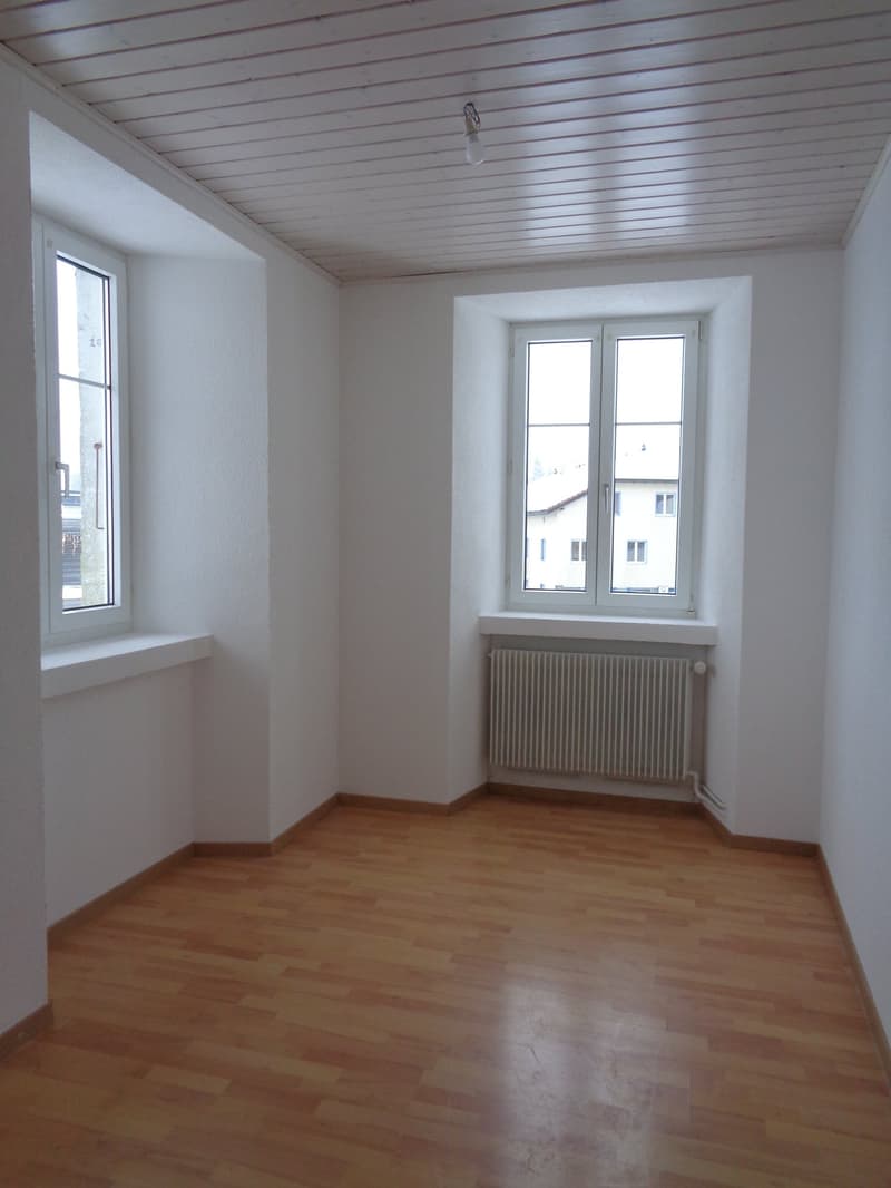empty room, wooden floors, two windows, central radiator, wooden ceiling