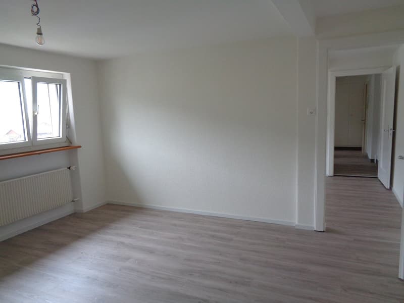 empty room, white walls, wooden floor, windows, radiator