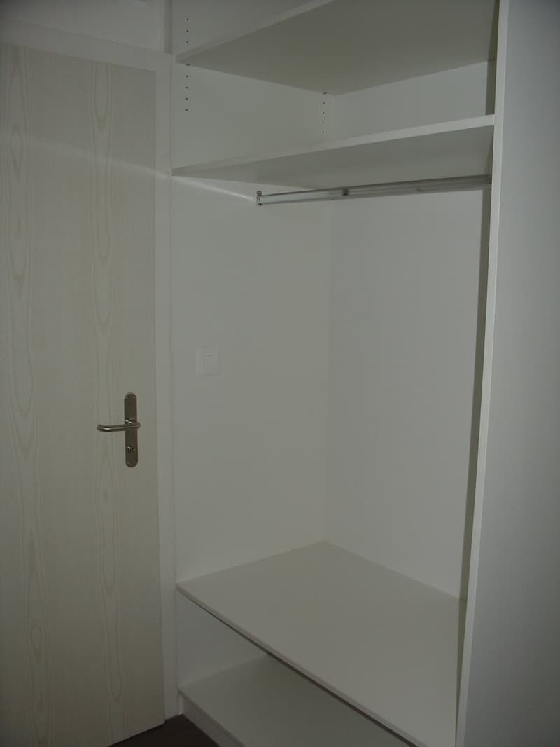 empty white wardrobe with shelves and hanging rod