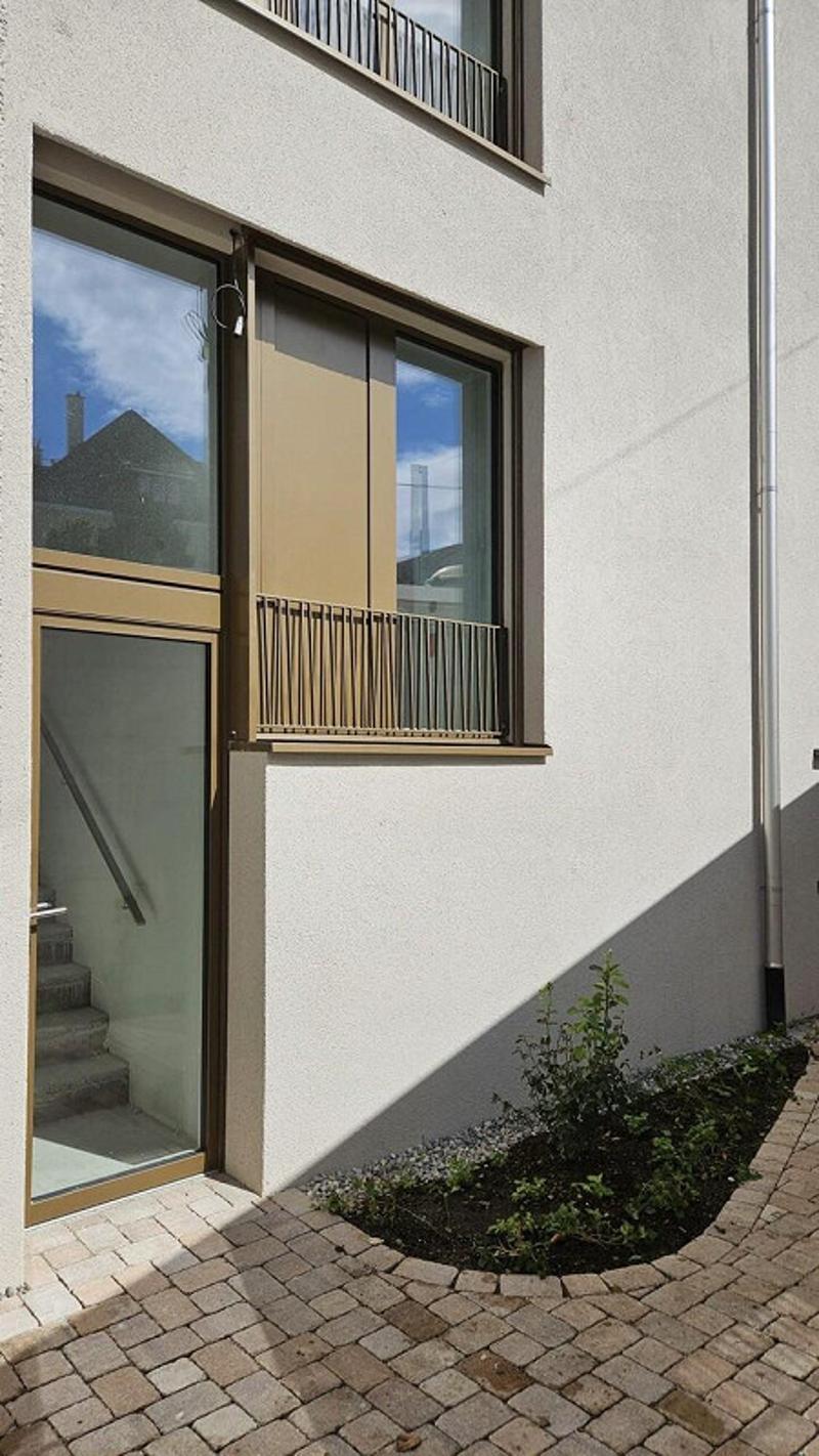 white facade, glass door, glass windows, balcony with metal grill, stairs, brick footpath
