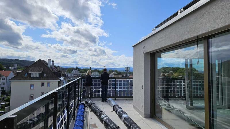 elevated balcony, large windows, solar panels on railing, view of mountains