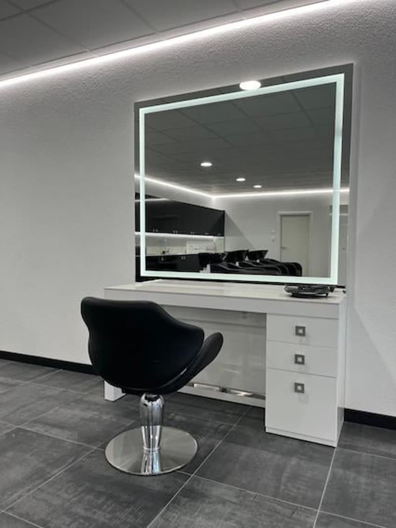 White desk with drawers, modern chair, large mirror, tiled floor, bright ceiling lights