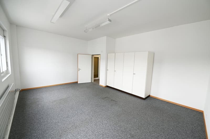 empty room with carpet floor, white walls, white door, two white cabinets, windows with blinds