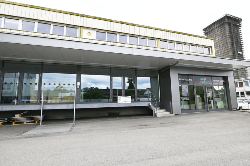 modern building with glass walls, glass doors, large windows, raised ground floor