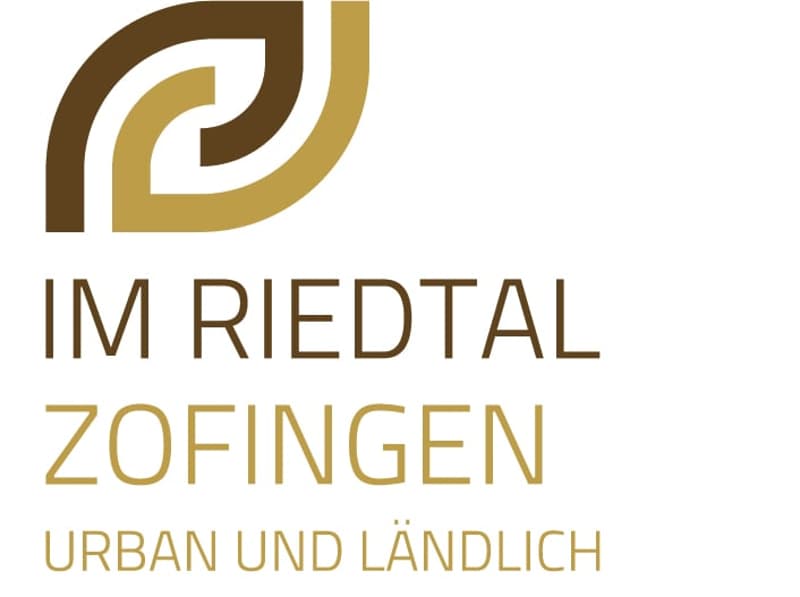 The image shows the logo for 'Im Riedtal Zofingen', which appears to be a real estate company or development. The logo features a stylized graphic design with curved shapes in brown and gold colors, along with the company name 'Im Riedtal Zofingen' writte