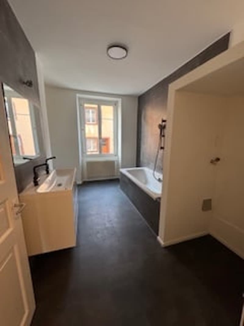 Bathroom with bathtub, sink, mirror, radiator, window