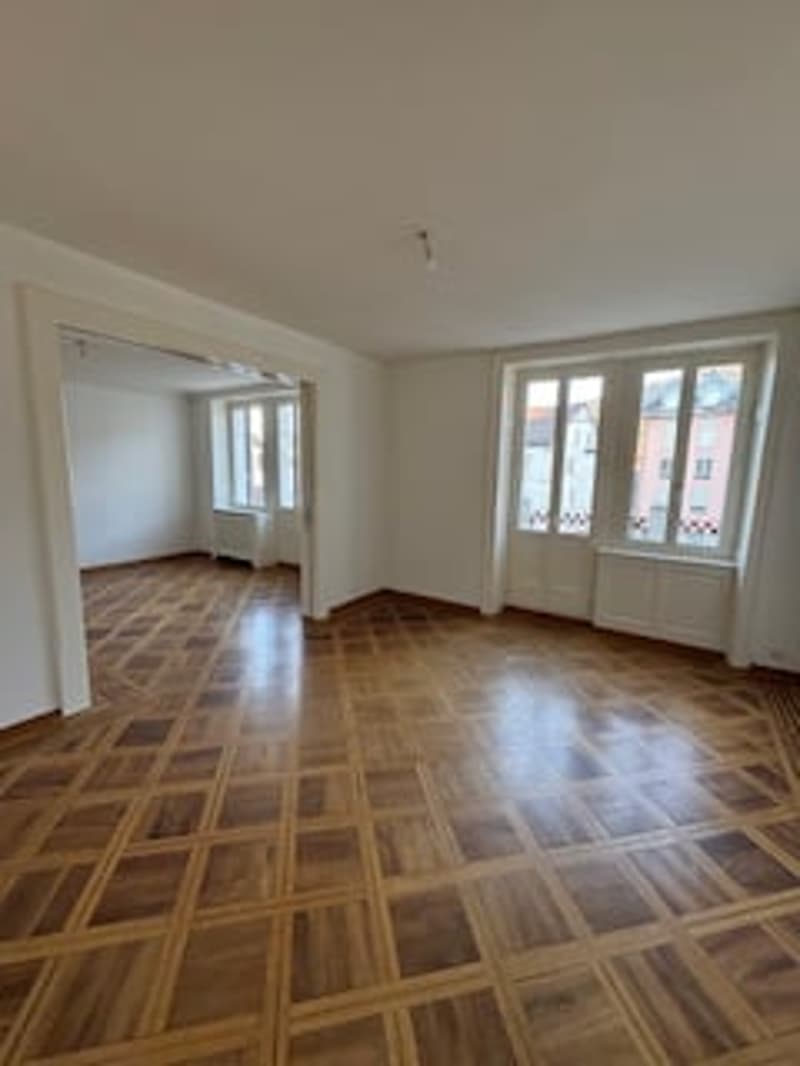 empty room, wooden parquet floor, white walls, windows, doors