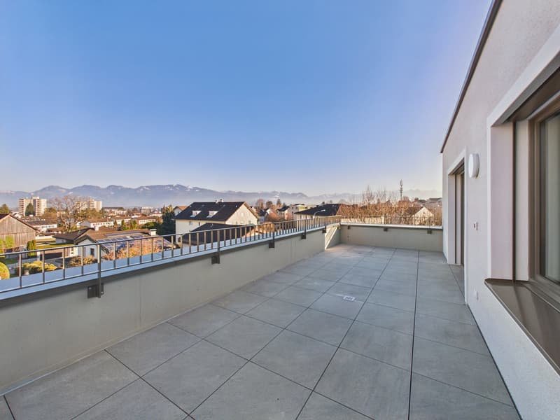 concrete balcony, tiled flooring, metal railings, distant view of mountains and buildings