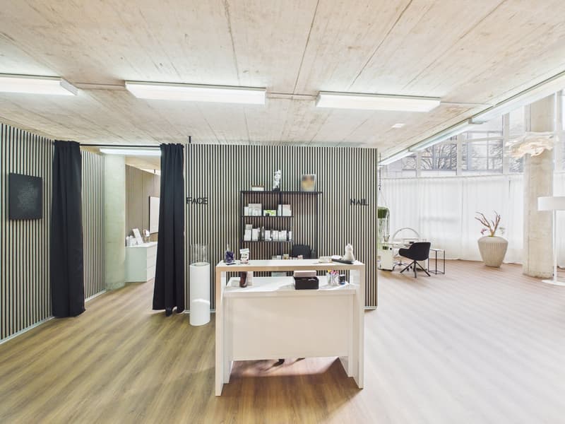 Modern interior with wooden flooring, white reception desk, shelf, and office chair. Black and white striped wall, black curtains, and windows.