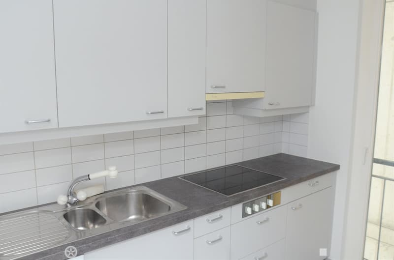 White cabinets, granite countertop, stainless steel sink, built-in oven, gas stove, and a window