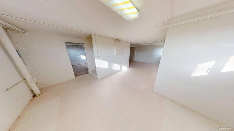 Empty room with white walls, white ceiling, fluorescent ceiling lamp, pipe along the wall, window on one wall