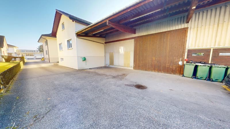 Residential house with driveway, attached garage, and a trash area with three bins