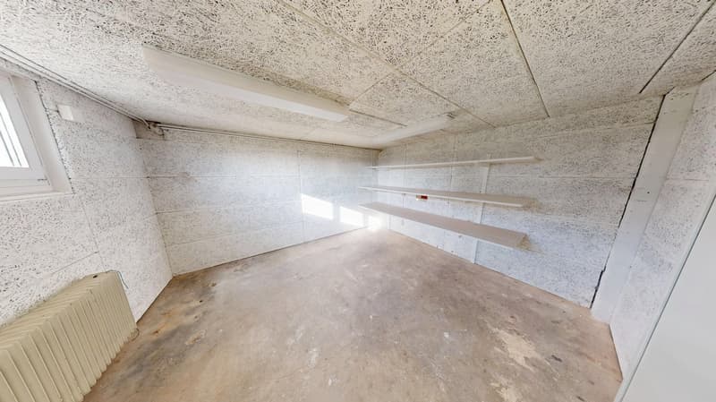 concrete floor, radiator, white walls, white ceiling, shelves, window