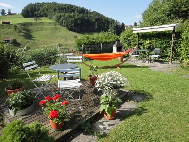 Deck, table, chairs, hammock, plants, and barbecue.