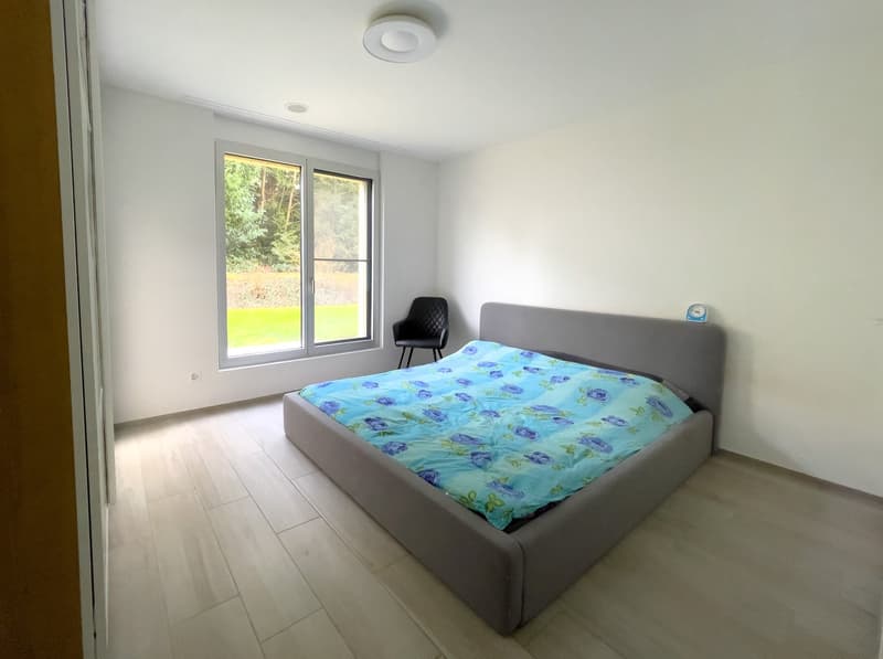Bedroom with bed, chair, and large window with view of the outside