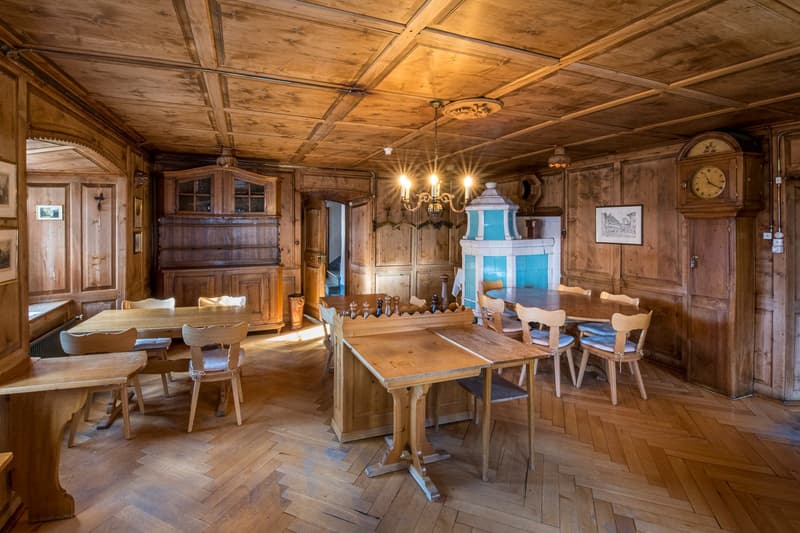 Wooden paneling, tables, chairs, wooden cabinet, fireplace, chandelier