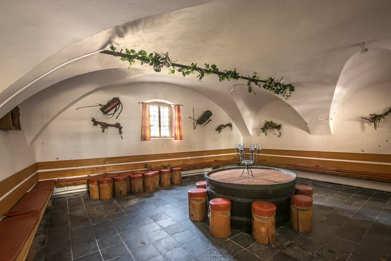 vaulted ceilings, wooden stools, round table, wooden benches, small window with curtains, green plants, metal structure, rustic design