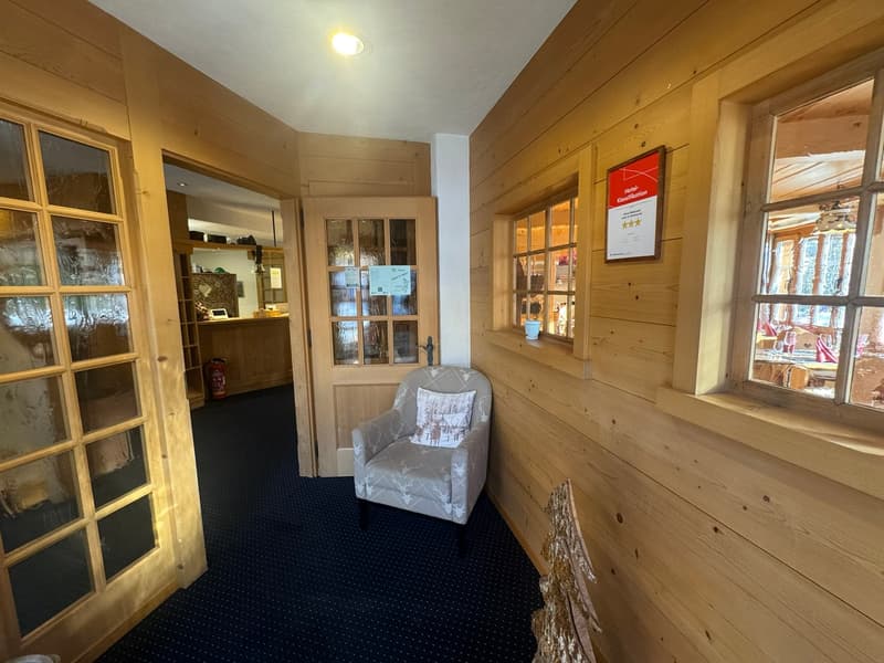 wooden walls, carpeted floor, chair with pillow, glass doors, fire extinguisher