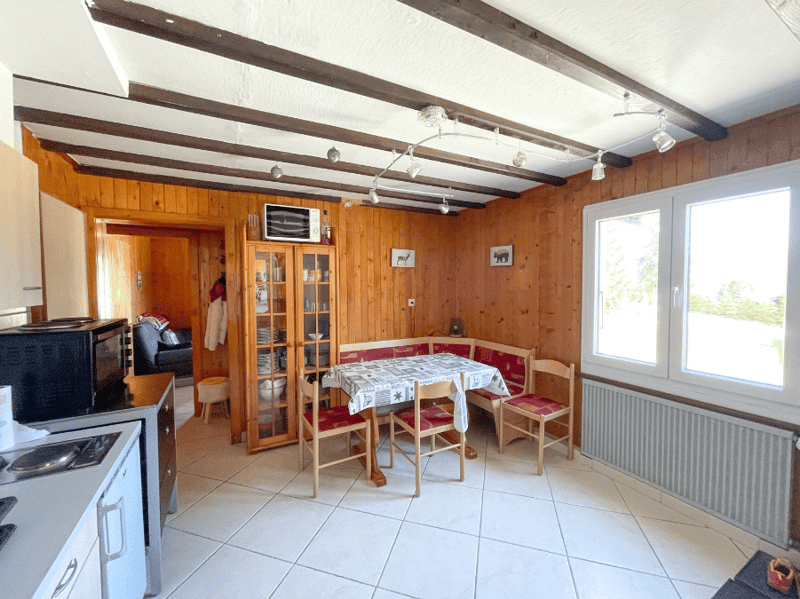 kitchen with dining area, wooden walls, white tiles, microwave, oven, dining table, chairs, radiator, cabinet, glass cabinet