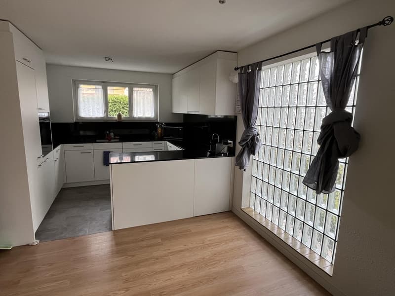modern kitchen, white cabinets, black countertops, island with sink, appliances, large glass window