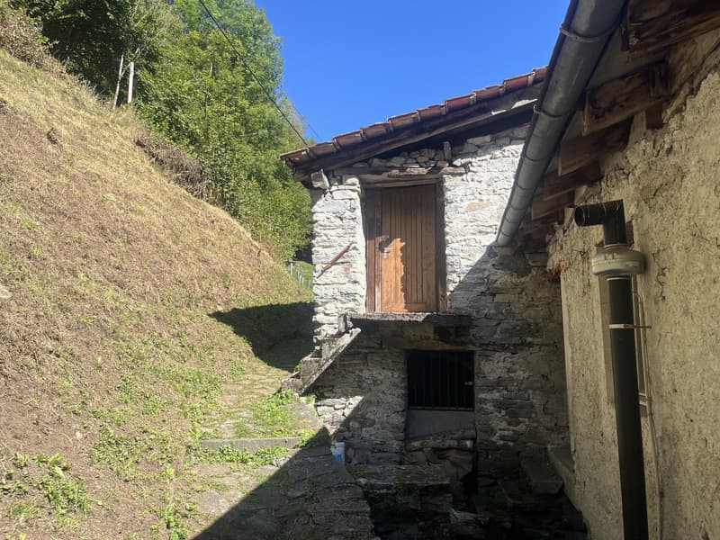 Old stone house, wooden door, red roof, steep hill