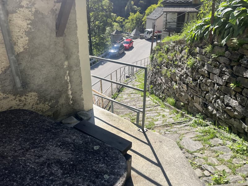 elevated platform with railing, stairs, wall, and cars driving on road