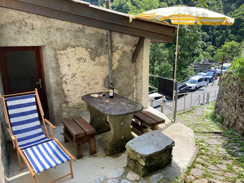 balcony with stone table, bench, outdoor chair, and an umbrella