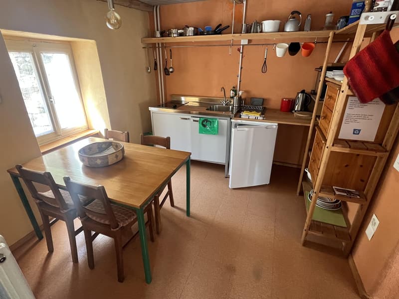 small kitchen, with table, washing machine, dishwasher, wooden shelves, gas stove, sink, window