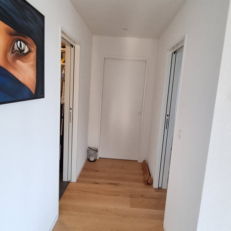 clean white walls, wooden floor, closed doors, basket