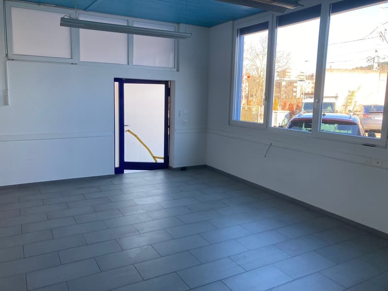 empty room, white walls, tile floor, single glass door, large windows, fluorescent ceiling lights