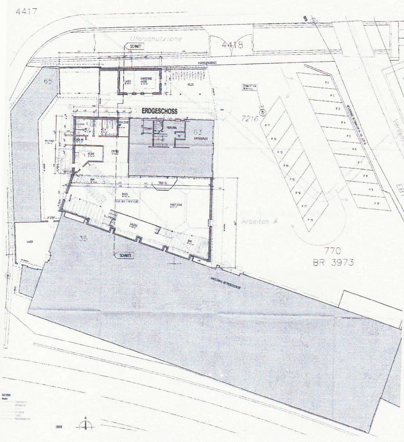 Ground floor plan of a building with multiple rooms, garage, stairwells, and parking spaces indicated.