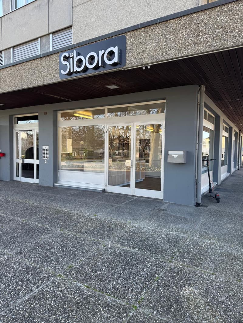 Facade of a building with glass doors and windows, name board reading 'Siboora', a scooter parked in front