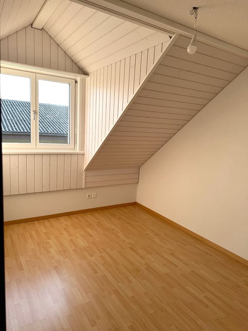 empty room, wooden floor, white walls, slanted ceiling, window