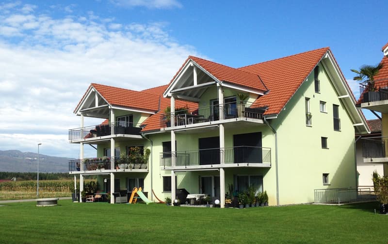 3 story house, yellow exterior, red roof, multiple balconies, garden, slide, patio furniture