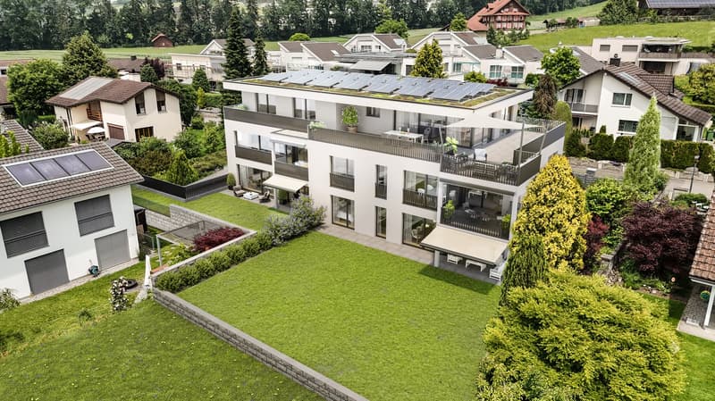 modern apartment building with solar panels, swimming pool, green lawns, large balconies, trees, and plants