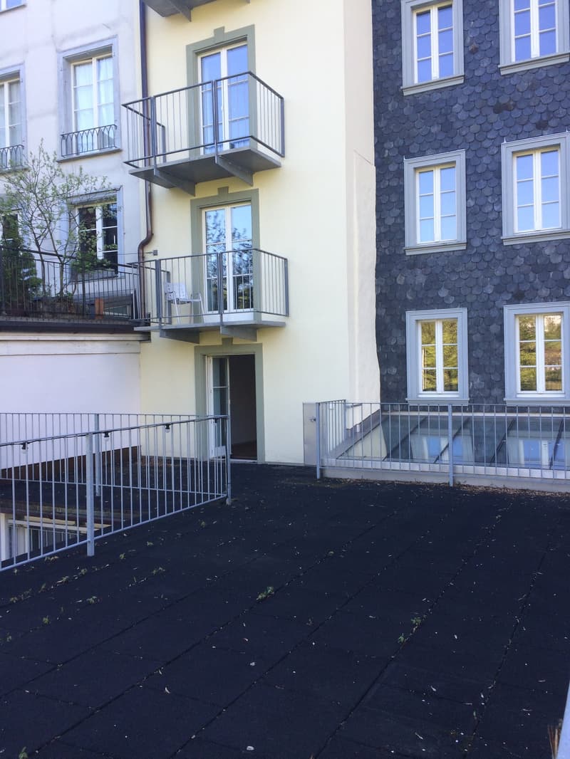 Concrete terrace, metal railing, multiple balconies, entrance to the house