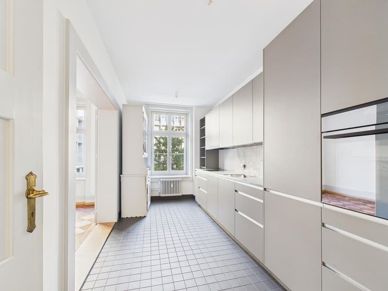 modern kitchen with white tiles, white cabinets, stainless steel sink, white appliances, window with view