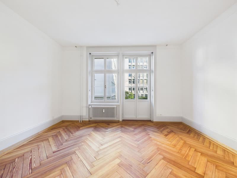 empty room, white walls, wooden parquet floor, large window, radiator