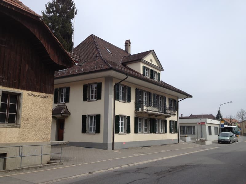 2 story house, brown roof, green shutters, beige facade, balcony, chimney