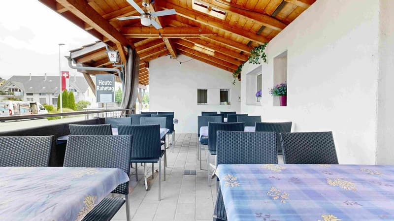 covered terrace, wooden ceiling, tables and chairs, plants, white walls