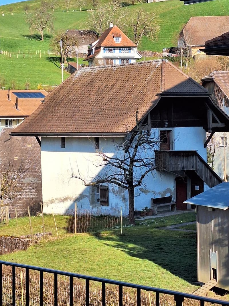 Traditional house, brown roof, white walls, wooden balcony, wooden stairs, garden, tree, fence