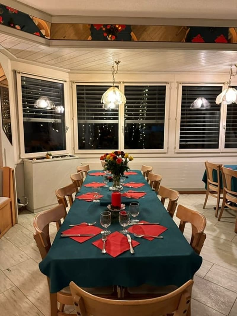dining table set with flowers, candles, wine glasses, place cards, forks, knives, napkins