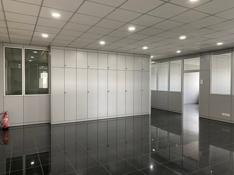 Tiled floor, white cabinets, fire extinguisher, multiple large windows, reflective floors