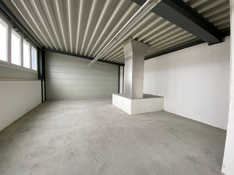 Empty room with white walls, concrete floor, metal ceiling beams, and large window