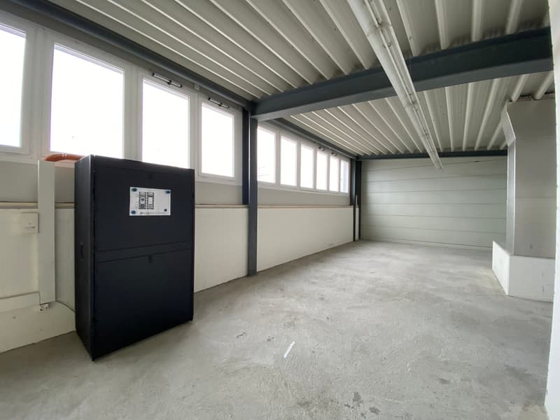 Industrial room with concrete floor, metal ceiling, multiple windows, no additional features