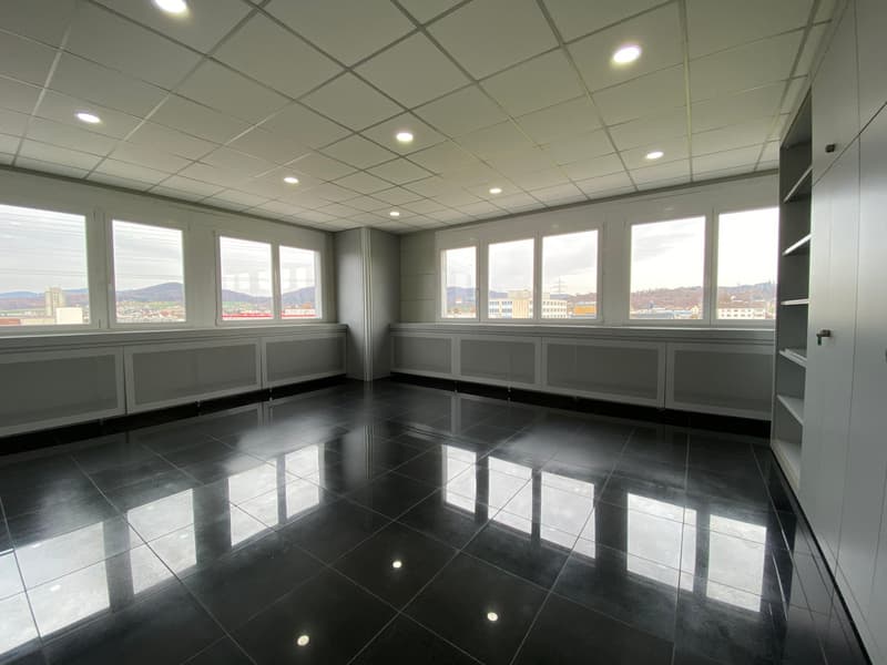 empty room with windows, large black tiles, white walls, no furniture