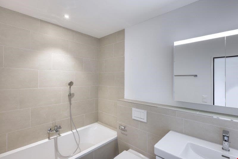Ein Badezimmer mit Badewanne, WC, Lavabo, Spiegelschrank