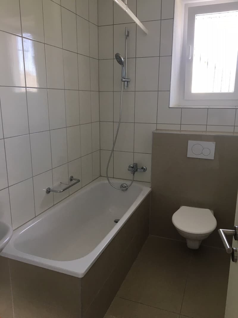 Schönes, helles Badezimmer mit Badewanne und tollen Materialien